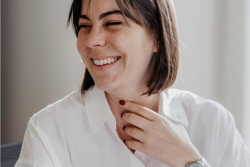 A person smiling with their head turned to the side